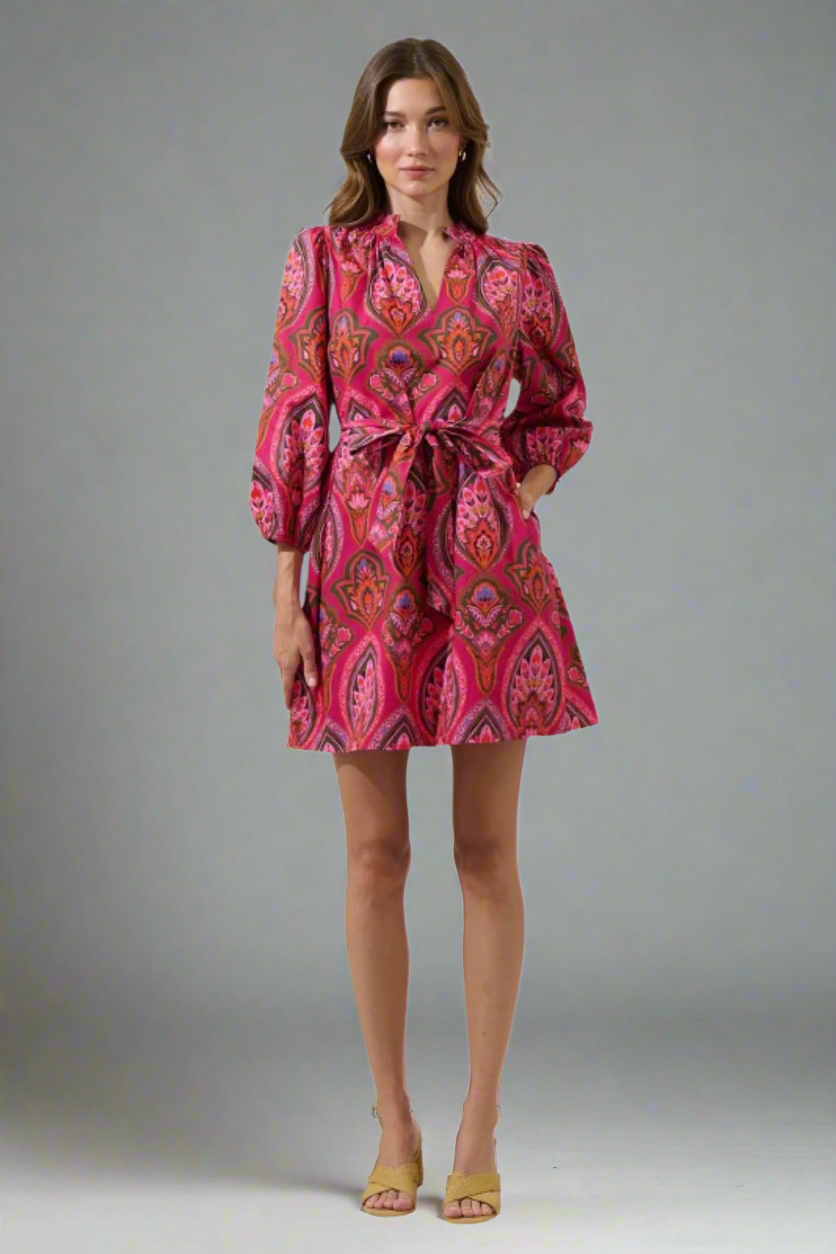 Woman wearing a pink patterned dress on a white background