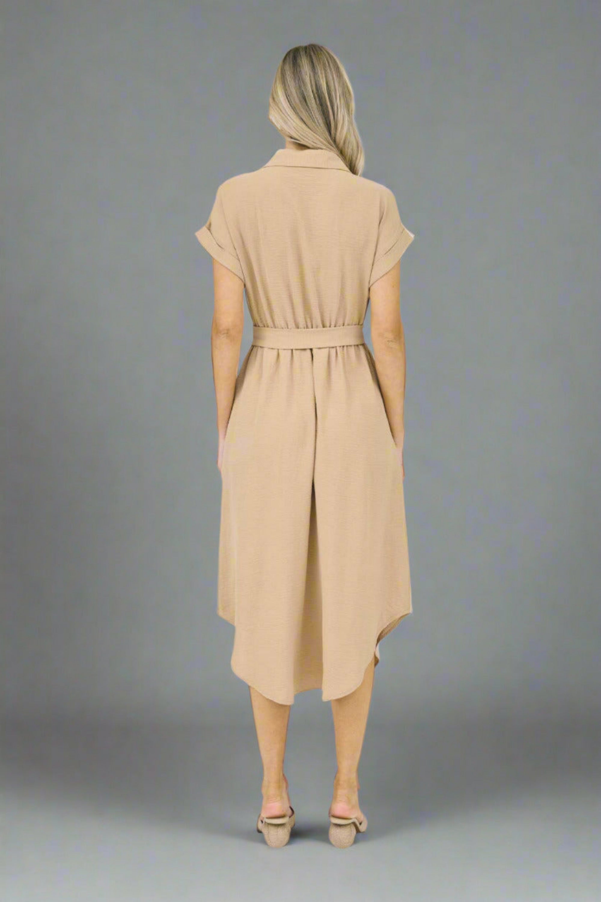 Woman wearing a beige dress on a white background