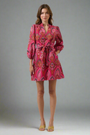 Woman wearing a pink patterned dress on a white background