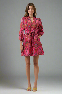 Woman wearing a pink patterned dress on a white background