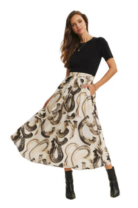Woman wearing a black top and patterned skirt on a white background
