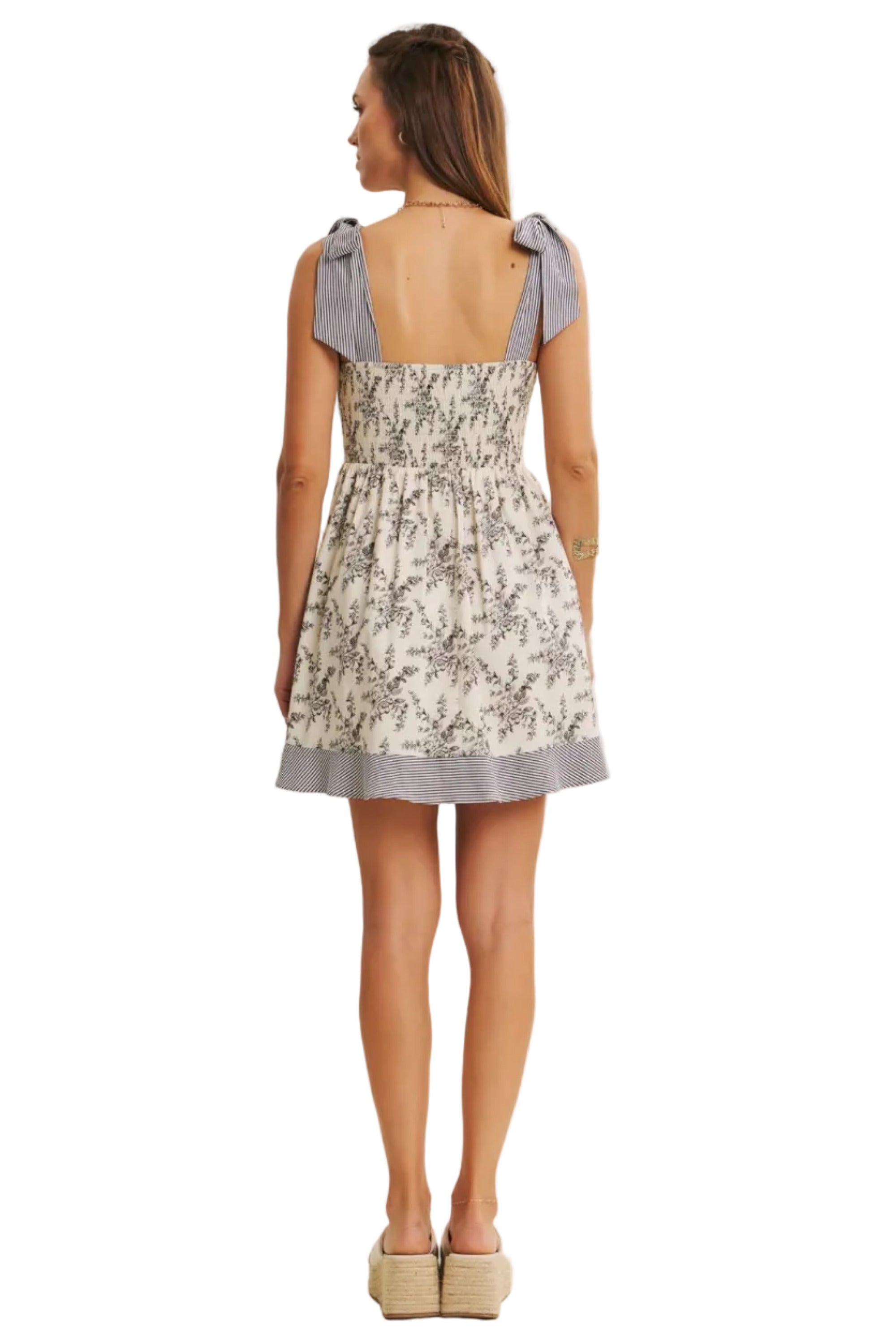 Woman wearing a floral dress with light-colored background