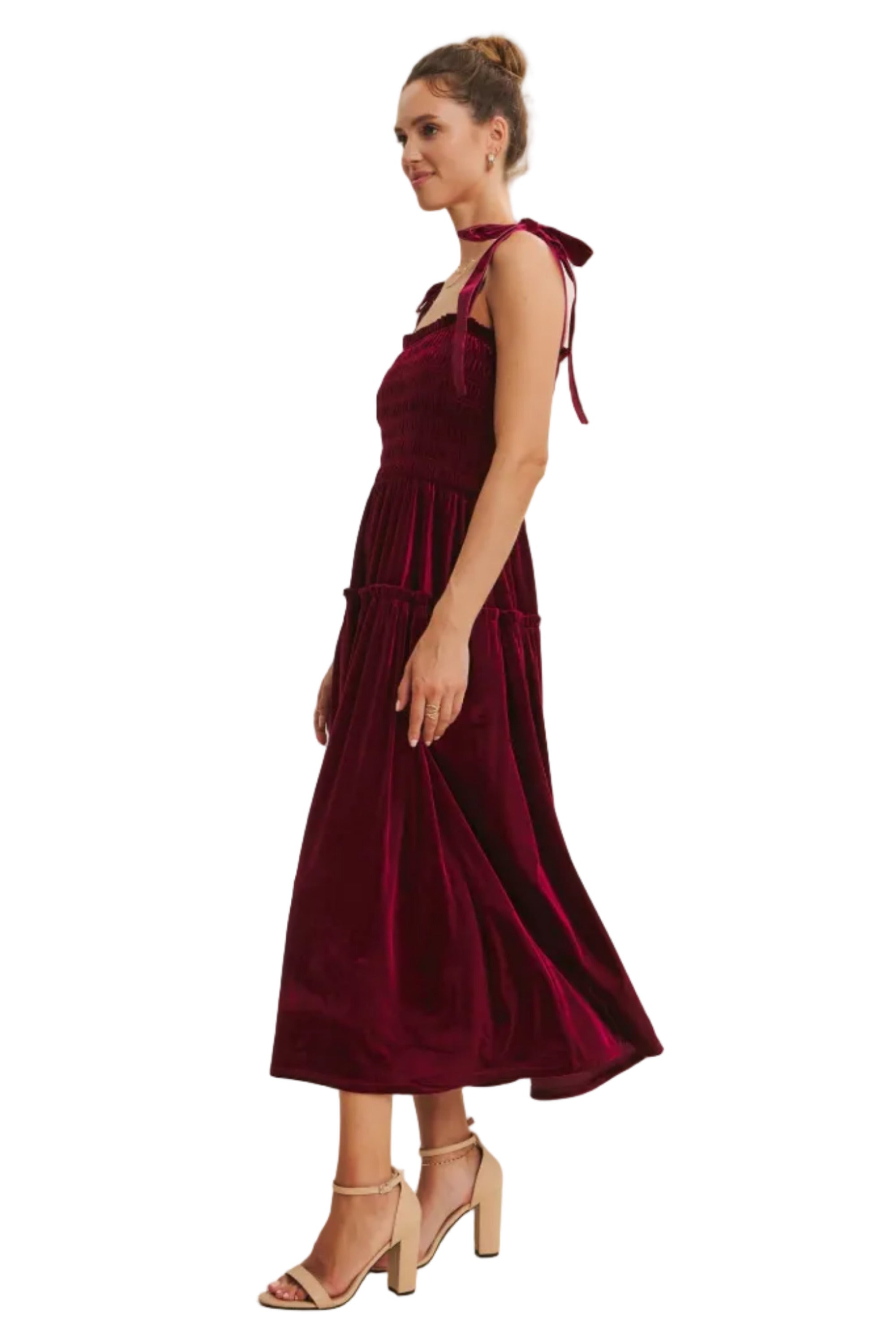 Woman wearing a burgundy velvet dress with a plain background