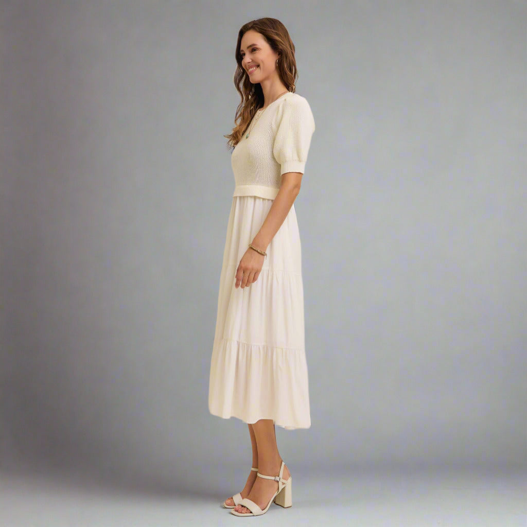 Woman wearing a white dress with a plain background