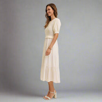 Woman wearing a white dress with a plain background