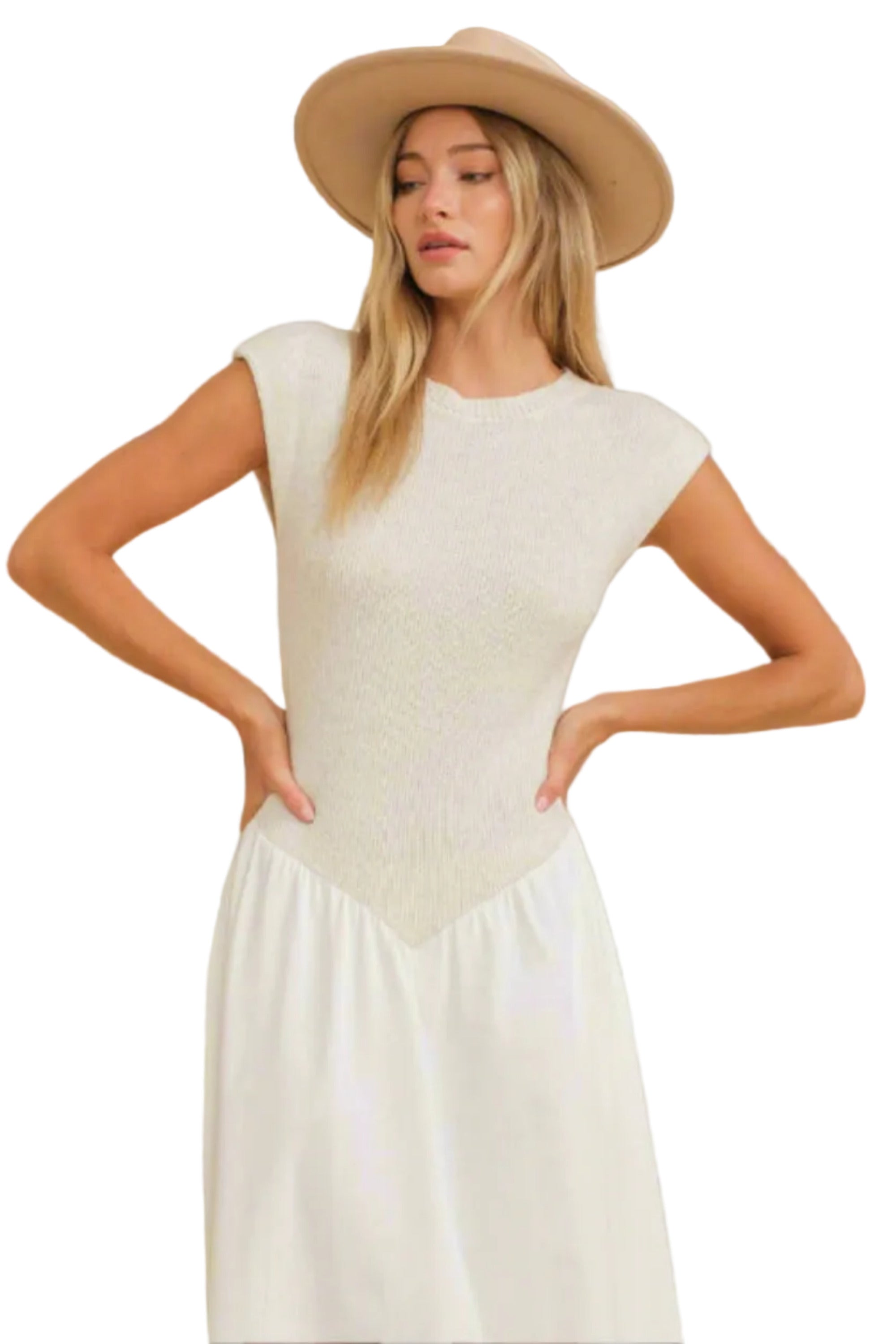 Woman wearing a beige top and white pants with a beige hat on a beige background