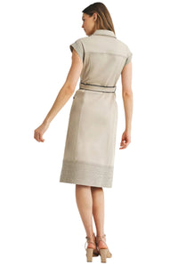 Woman wearing a beige dress with a belt on a white background