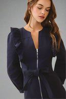 Navy blue dress with ruffled sleeves and a bow detail on a beige background