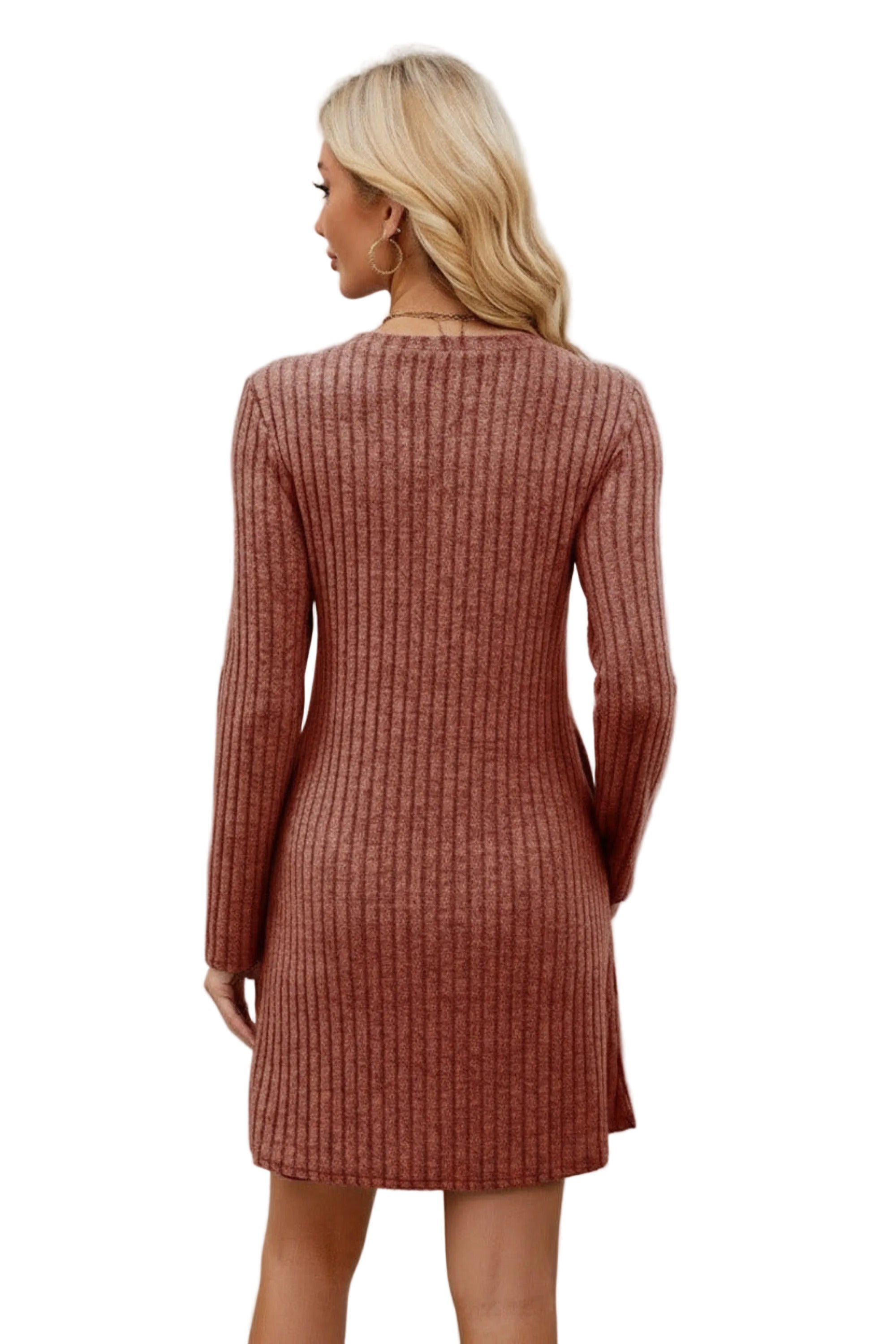 Woman wearing a brown ribbed dress standing in front of a white wall.