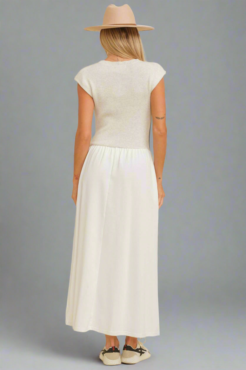 Woman wearing a white dress and beige hat against a beige background